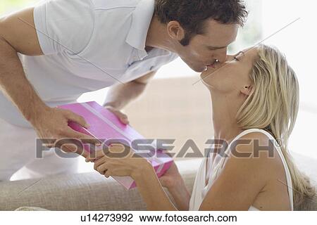 Man giving present to woman and kissing on lips View Large Photo Image Stock Image - Man giving present to woman and kissing on lips. Fotosearch