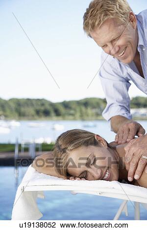 Man rubbing woman's back on lounge chair View Large Photo Image Stock Image - Man rubbing woman's back on lounge chair. Fotosearch