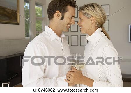 Mid adult couple holding hands and drinking champagne View Large Photo Image Stock Image - Mid adult couple holding hands and drinking champagne. Fotosearch