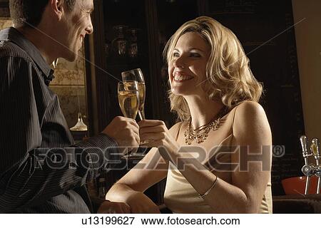 Mid adult couple toasting with champagne View Large Photo Image Stock Photo - Mid adult couple toasting with champagne. Fotosearch