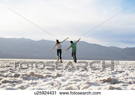 Woman and man running with arms outstretched View Large Photo Image Stock Image - Woman and man running with arms outstretched. Fotosearch