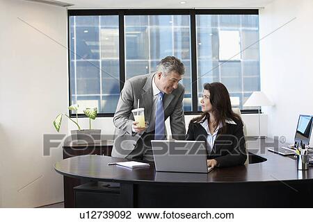 Stock Image - Businessman flirting with female manager. Fotosearch