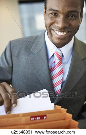 Businessman going through files View Large Photo Image Stock Image - Businessman going through files. Fotosearch