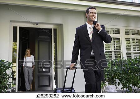 Businessman leaving for business trip, wife at door View Large Photo Image Stock Image - Businessman leaving for business trip, wife at door. Fotosearch