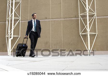 Picture - Businessman pulling briefcase. Fotosearch