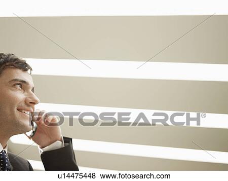 Stock Photo - Businessman talking on phone (low angle view). Fotosearch
