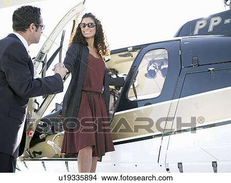 Businesspeople shaking hands by helicopter View Large Photo Image Picture - Businesspeople shaking hands by helicopter. Fotosearch