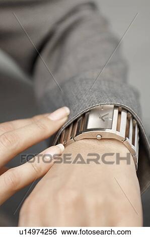 Businesswoman checking the time from wrist watch (close-up) View Large Photo Image Stock Photograph - Businesswoman checking the time from wrist watch (close-up). Fotosearch