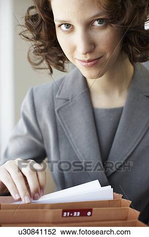 Businesswoman going through files View Large Photo Image Stock Image - Businesswoman going through files. Fotosearch