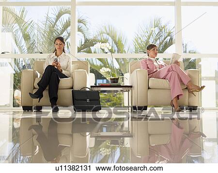 Two businesswomen sitting on armchairs (low angle view) View Large Photo Image Stock Image - Two businesswomen sitting on armchairs (low angle view). Fotosearch