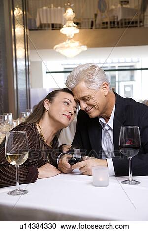 Stock Image - Caucasian mature adult male proposing to prime adult female.. Fotosearch