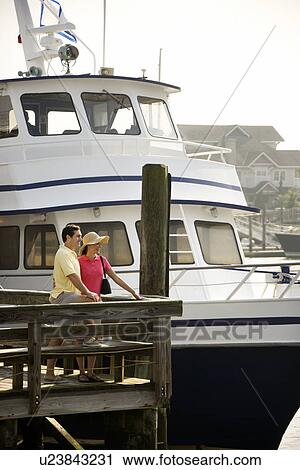 Couple at dock with boat View Large Photo Image Stock Image - Couple at dock with boat. Fotosearch