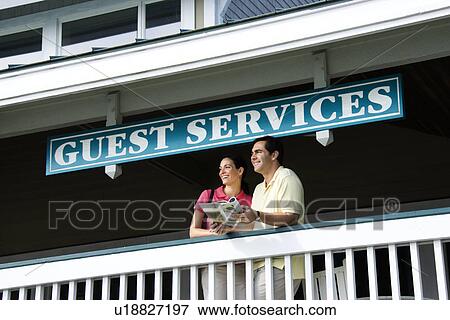 Stock Photo - Couple looking out at guest services . Fotosearch
