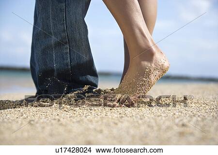 Feet and legs of mid-adult Caucasian couple standing together on beach. View Large Photo Image Picture - Feet and legs of mid-adult Caucasian couple standing together on beach. . Fotosearch