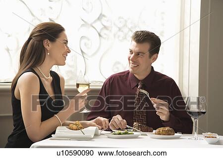 Mid adult Caucasian couple dining in restaurant and smiling. View Large Photo Image Stock Image - Mid adult Caucasian couple dining in restaurant and smiling.. Fotosearch