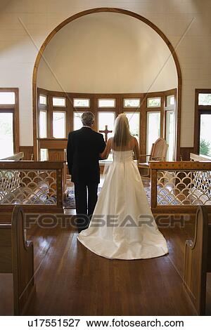 Stock Photo - Portrait of bride and groom at alter of a church.. Fotosearch