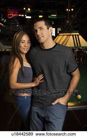 Stock Photo - Portrait of couple relaxing at pub.. Fotosearch