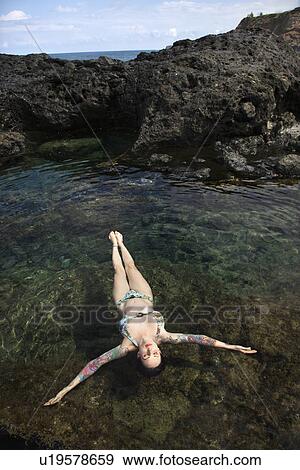 Sexy Caucasian woman in bikini floating in tidal pool View Large Photo Image Stock Photo - Sexy Caucasian woman in bikini floating in tidal pool . Fotosearch