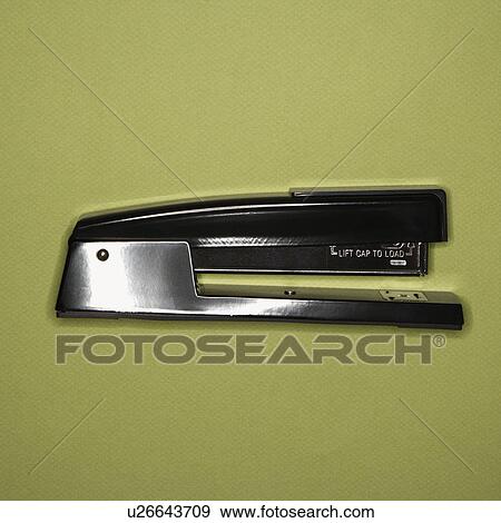 Stock Photo - Black stapler on green background. Fotosearch