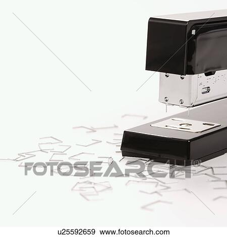 Stock Photo - Black stapler on white background surrounded by individual staples. Fotosearch