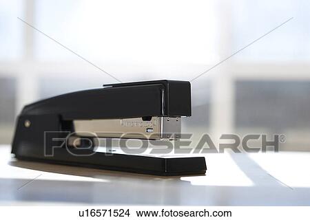 Picture - Black stapler with window in background. Fotosearch