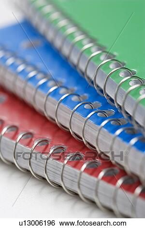 Stock Photograph - Close up of three spiral bound notebooks stacked up.. Fotosearch