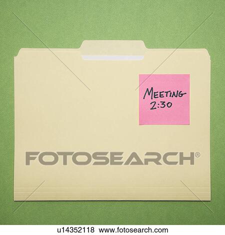 Stock Photo - Folder with pink sticky note reminder for a meeting on a green background.. Fotosearch