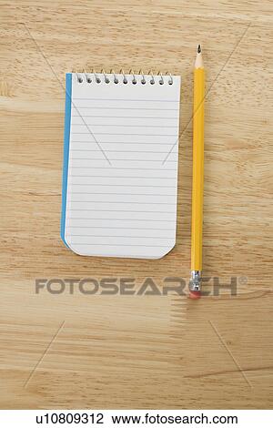 Stock Image - Pencil beside open spiral bound notepad. Fotosearch