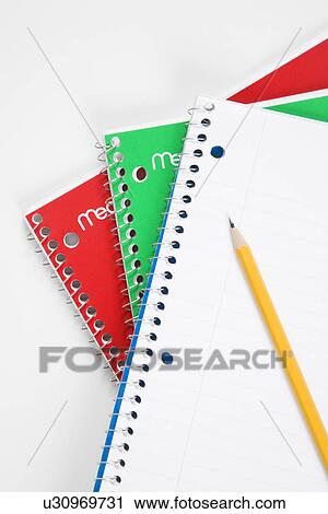 Stock Image - Pencil on top of three spiral bound notebooks. Fotosearch