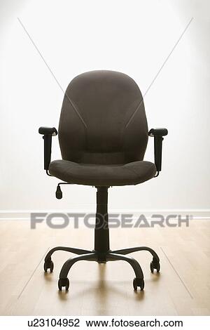 Stock Image - Still life of empty office desk chair. Fotosearch