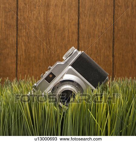 Stock Image - Studio shot of vintage camera with wood paneling in background. Fotosearch