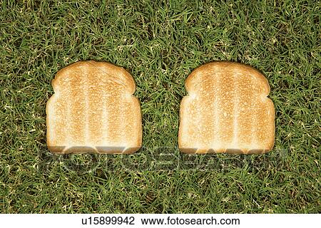 Stock Image - Two slices of toast on grass.. Fotosearch