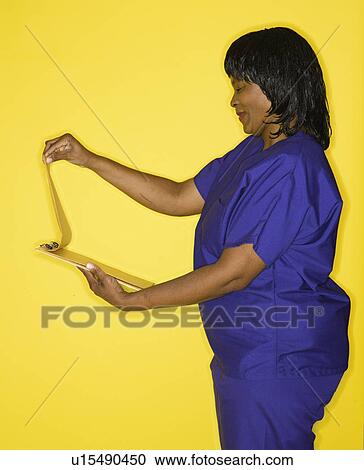 African-American mid-adult woman n medical uniform smiling reading chart. View Large Photo Image Stock Image - African-American mid-adult woman n medical uniform smiling reading chart.. Fotosearch