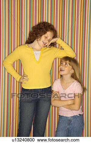 Stock Image - Caucasian female child leaning on smaller female child.. Fotosearch