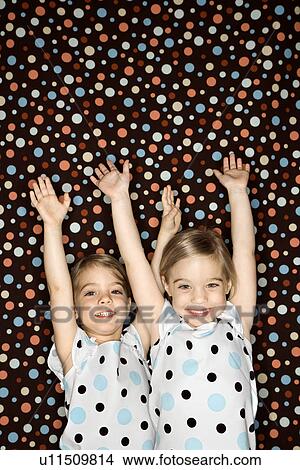 Female children Caucasian twins looking at viewer with arms raised. View Large Photo Image Picture - Female children Caucasian twins looking at viewer with arms raised.. Fotosearch