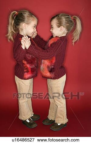 Stock Photo - Female twins standing in dance stance. Fotosearch