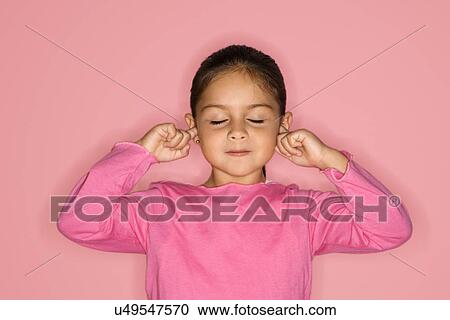 Stock Image - Girl with fingers in ears and eyes closed. Fotosearch