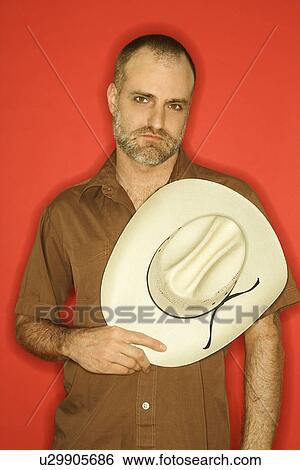 Man with beard and receding hairline holding cowboy hat View Large Photo Image Stock Photograph - Man with beard and receding hairline holding cowboy hat. Fotosearch