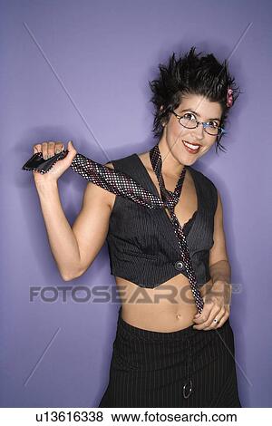 Portrait of smiling Hispanic woman wearing eyeglasses and necktie with exposed midriff standing against purple background. View Large Photo Image Stock Photo - Portrait of smiling Hispanic woman wearing eyeglasses and necktie with exposed midriff standing against purple background.. Fotosearch