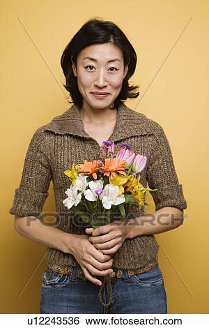 Stock Photograph - Woman holding bouquet of flowers. Fotosearch