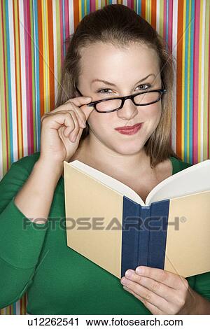 Young Caucasian female adult reading and looking at viewer over glasses. View Large Photo Image Stock Image - Young Caucasian female adult reading and looking at viewer over glasses.. Fotosearch