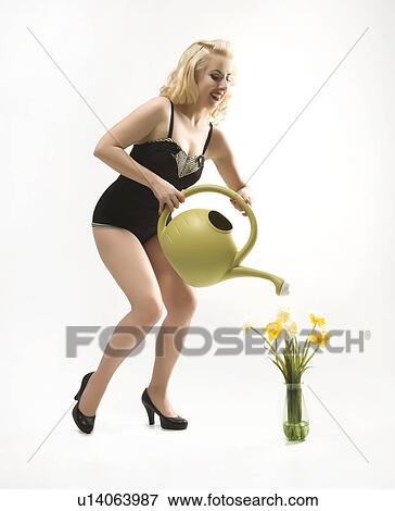 Attractive woman wearing retro swimsuit in pinup pose watering flowers View Large Photo Image Stock Photo - Attractive woman wearing retro swimsuit in pinup pose watering flowers. Fotosearch