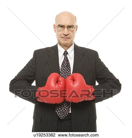 Stock Image - Businessman wearing boxing gloves.. Fotosearch