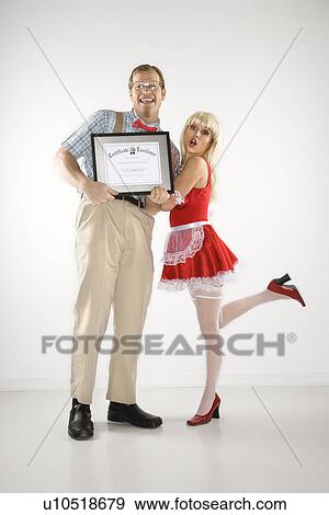 Stock Photo - Man dressed like nerd holding certificate with woman dressed in french maid outfit. Fotosearch