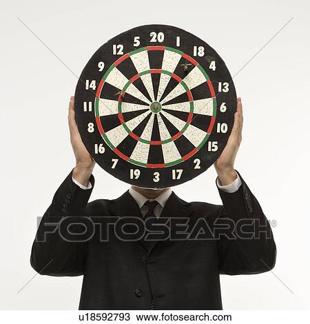Man wearing suit and holding dartboard in front of face. View Large Photo Image Stock Image - Man wearing suit and holding dartboard in front of face.. Fotosearch