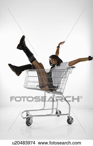 Mid-adult African American woman in mini skirt and boots sitting in shopping cart with arms and legs out. View Large Photo Image Picture - Mid-adult African American woman in mini skirt and boots sitting in shopping cart with arms and legs out.. Fotosearch