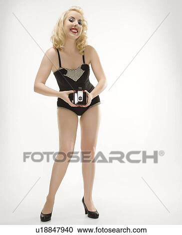 Woman wearing retro swimsuit in pinup pose with vintage camera View Large Photo Image Stock Image - Woman wearing retro swimsuit in pinup pose with vintage camera. Fotosearch
