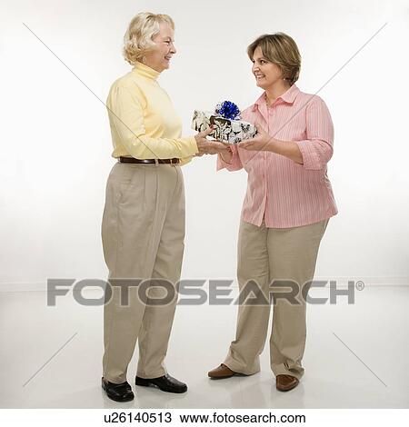 Stock Image - Women exchanging gifts. Fotosearch
