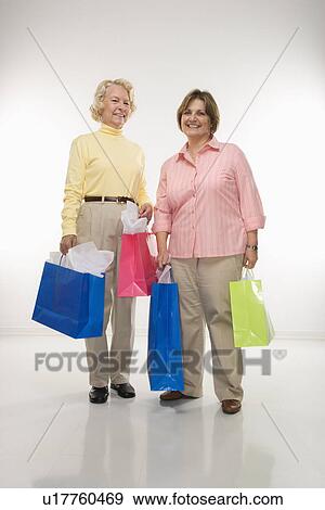 Stock Photo - Women holding gift bags. Fotosearch