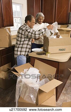 Couple packing moving boxes in kitchen View Large Photo Image Stock Image - Couple packing moving boxes in kitchen. Fotosearch